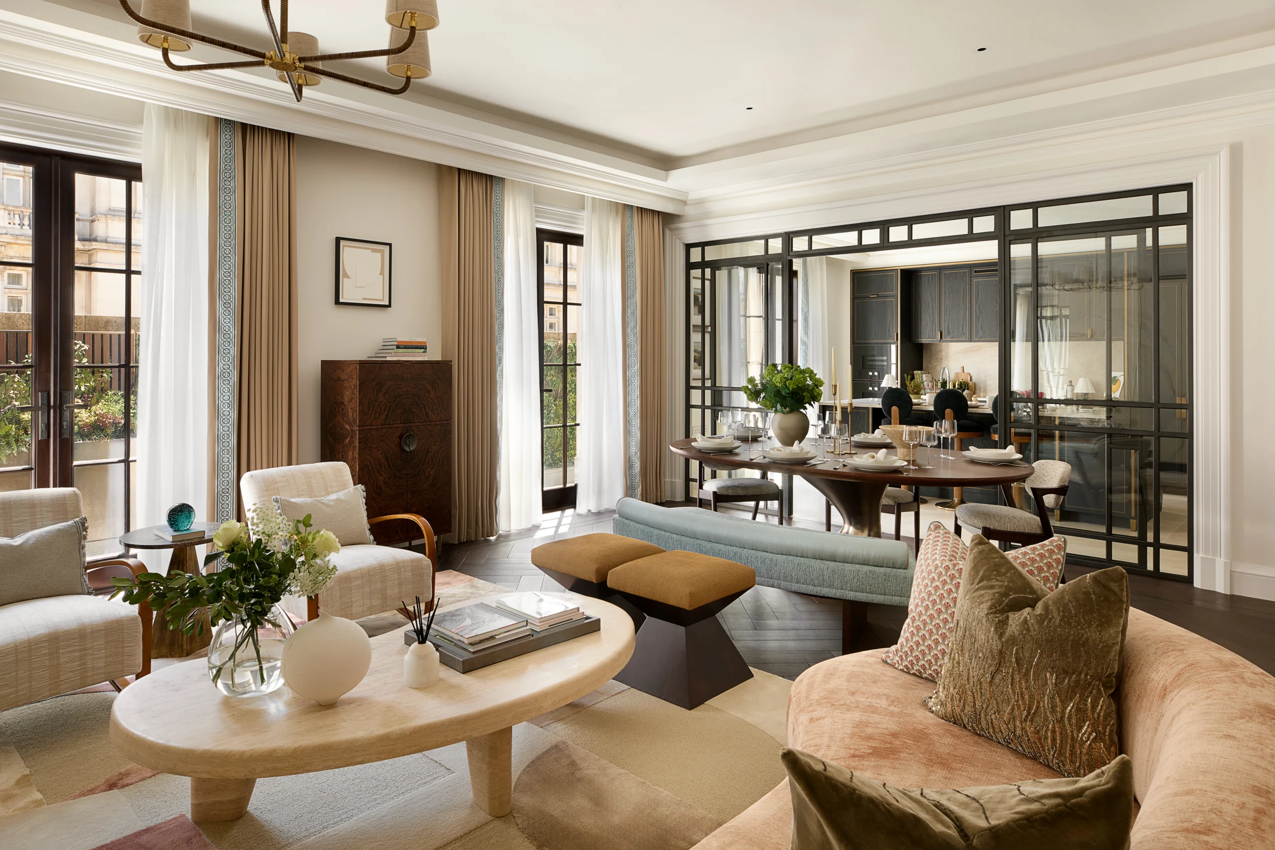 Reception room showing living space with two terrace doors looking towards the kitchen visible through glass crittal doors