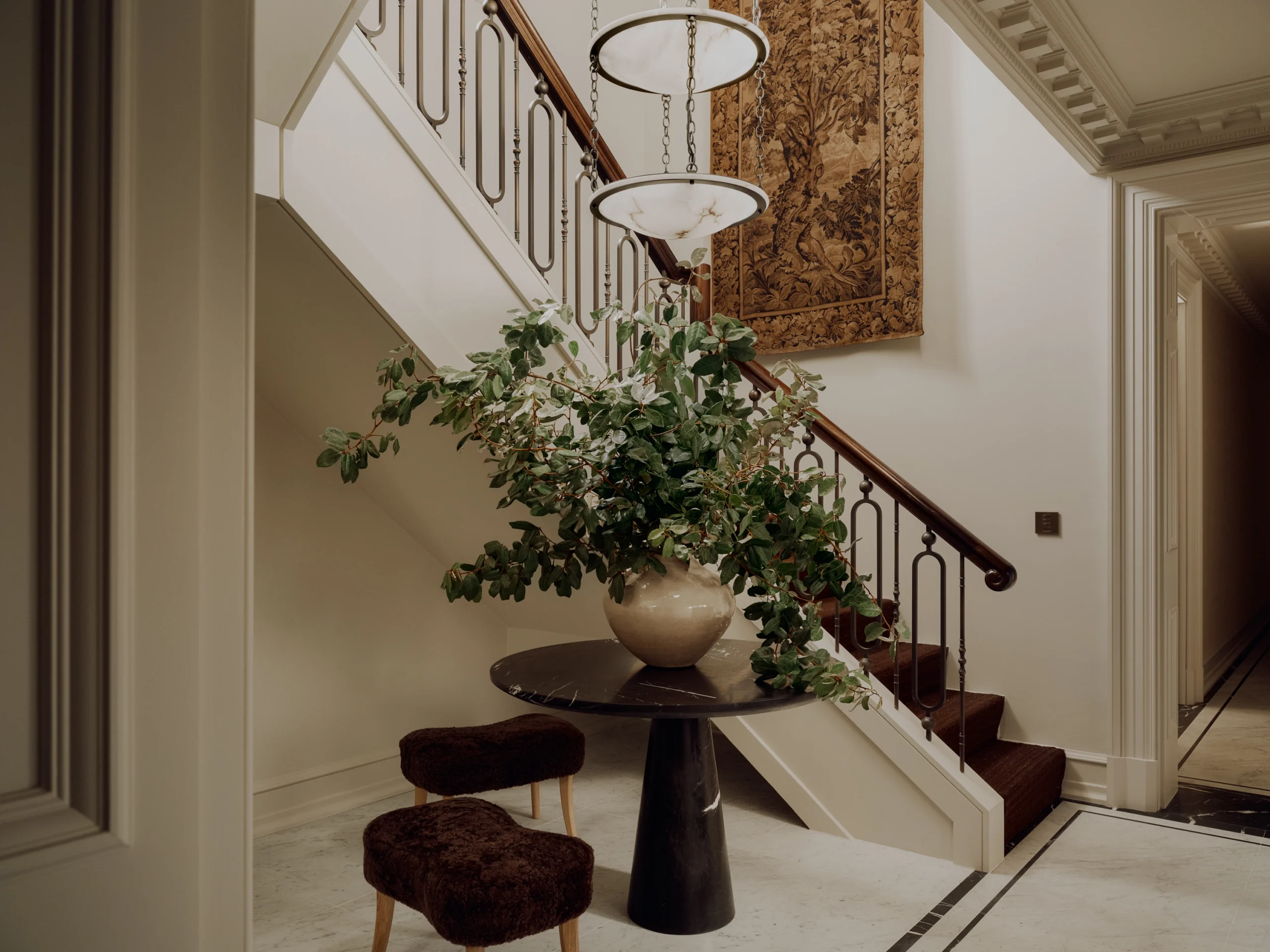 An Oprhan Works chandelier and antique tapestry connecting the two floors
